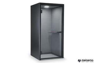 Zwarte belcel met grijze binnenwanden, glazen deur met zwart frame, LED-verlichting en audioapparatuur zichtbaar.