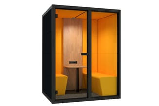 Kleine akoestische belcel met zwart frame, oranje wanden, houten middenwand, gele zitcubes en tafelblad, gesloten deuren.