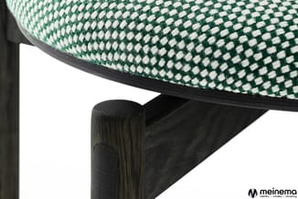 Stoel met groen-wit geruit bekleding en zwart houten frame, zijaanzicht detail.