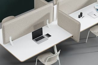 Werkplek met wit bureau, beige akoestische scheidingspanelen, laptop, notebook en beige stoel met witte poten.