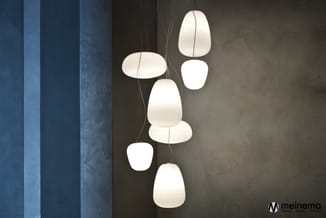 Hangende witte pendant verlichting met gerimpeld papier in verschillende vormen en maten, opgesteld in moderne grijze ruimte