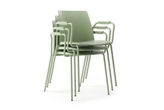 Gestapelde armleunstoelen in lichtgroen, modern design met gesloten zitting en rugleuning, metalen frame.