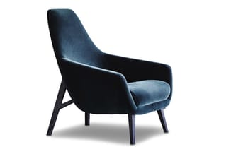Blauwe fauteuil met hoge rugleuning, fluweelachtig materiaal, zwarte houten poten, modern design, tegen witte achtergrond.