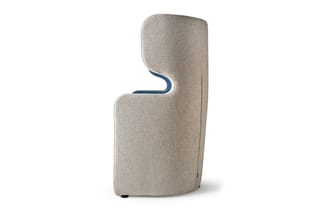 Beige stofbeklede fauteuil met blauwe binnenzijde, ergonomische S-vorm, wieltjes aan onderkant, vrijstaand tegen witte achter
