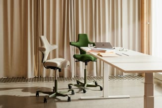 Moderne kantoorruimte met witte bureau, groene en beige ergonomische bureaustoel met wielen, laptop en notities tegen beige g