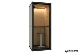 Zwarte belcel met beige/bruine binnenkant, ronde tafel, LED-verlichting bovenin, glazen deur, grijs vloermateriaal.