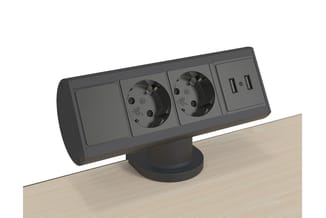 Zwarte bureaublad powermodule op houten tafel met twee stopcontacten, twee USB-poorten en één schakelaar.