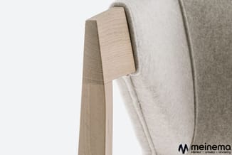 Houten kapstok met lichte wollen jas, detail van houtstructuur en textiel textuur.