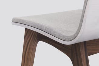 Stoel met grijs gestoffeerde zitting en rugleuning, wit houten frame en donkerbruin houten poten met streeppatroon.