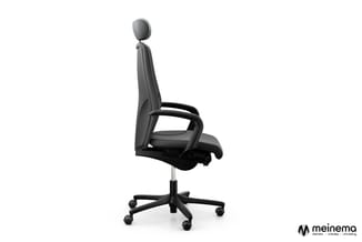 Zwarte ergonomische bureaustoel met mesh-rugleuning, verstelbare hoofdsteun, armleuningen en zwenkvoet met wielen op witte ac