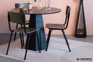 Ronde tafel met blauwe voorkant en twee zwarte stoelen met grijze zittingen in moderne kantoorinrichting.