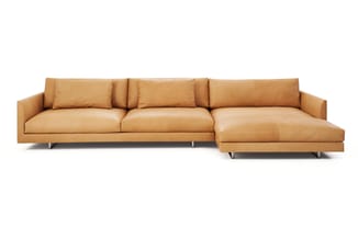 Caramelkleurige leren hoekbank met drie zitplaatsen en chaise longue, moderne vormgeving met metalen poten.