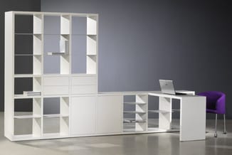 Modulair kastensysteem wit met glazen deuren, open vakken en laden, uitgebreid met bureau en paarse stoel in kantooromgeving.