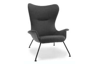 Grijze fauteuil met hoge gebogen rugsteun, zwarte metalen poten, armsteunen en zitgedeelte met kussens.