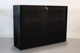 Zwarte kastenwand met metalen framewerk, voorzien van ventilatieopeningen en slot, geplaatst in een lichte ruimte.