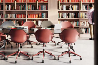 Moderne kantoorruimte met rode draaibare conferentiestoel met wielen, zwarte vergadertafel en houten boekenkasten op achtergr