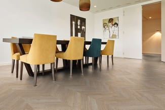 Vergadertafel zwart met gele en groene stoelen, houten visgraatvloer, witte wanden, artwork.