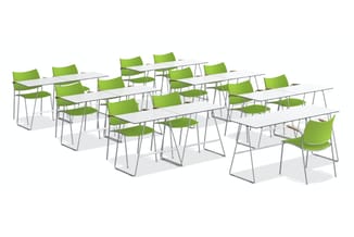 Vergaderruimte met rechthoekige witte tafels en groene kunststof stapelstoelen met grijs metalen frame, in rijen gerangschikt