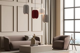 Moderne loungeset met grijze stofsofa, ronde fauteuil en wit salontafel. Vier hangende design-pendels in grijs, wit, rood en