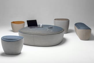 Modulaire zitgroep met grijs linnen bekleding: ronde centrale tafel met blauwe zitkussens, vier bijzettafels en twee rechthoe