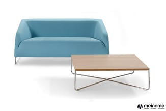 Blauwe moderne zitbank met metalen poten en houten salontafel met X-vormig onderstel op witte achtergrond.
