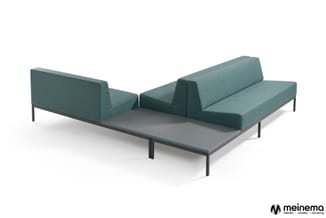 Modulaire bank in grijsgroene stof met zwarte metalen poten, twee delen onder hoek opgesteld rond grijze tafel.