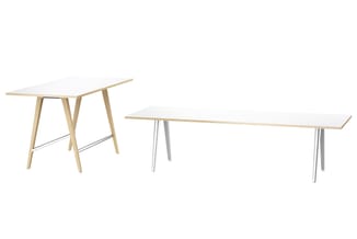 Drie vergadertafels: links houten tafel met schuin blad en houten poten, midden en rechts lange tafels met wit blad en metale