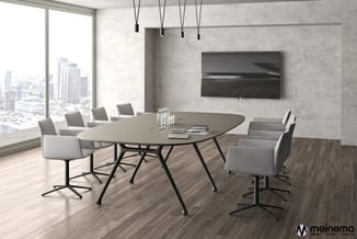 Moderne vergaderruimte met ovale tafel, grijze stoelen, wandmontage TV, hangende verlichting en groot raamfront met stadsuitz