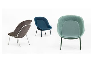 Drie moderne fauteuils: bruingrijs met wit frame, donkerblauw met zwart frame, en mintgroen met donkergroen frame.