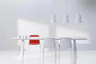 Moderne vergadertafel met witte onderstel en grijze blad. Vier stoelen: drie wit, één rood. Drie witte hangende pendellampen