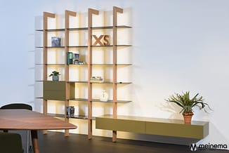 Moderne kastenwand met houten raamwerk, grijze metalen leggers, grijsgroene schuifdeuren en ingebouwde verlichting. Onderaan