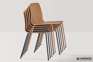 Stapelbare stoelen met houten zitting in natuurtint en metalen frame in verschillende kleuren, gestapeld weergegeven.