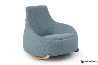 Grijsblauwe schommelfauteuil met gestoffeerde zitting, houten rockers en bruin lederen armsteun.
