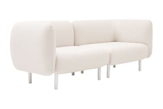Crèmekleurige sofa met afgeronde vormen, modulair design met cilindervormige armleuningen en witte houten poten.