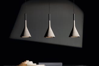 Drie hangende kegelvormige designlampen in beige/grijs, minimalistisch interieur met donkere wand en lichte oppervlakte erond