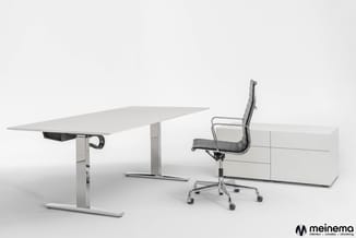 Wit elektrisch verstelbaar bureau met crank-systeem, zwarte bureauvoet en witte sideboard met lades, met zwarte ergonomische