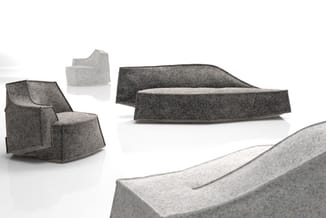 Collectie grijze akoestische zitmeubels: fauteuil met wielbasis, loungebank en leunstoel in viltachtig materiaal.