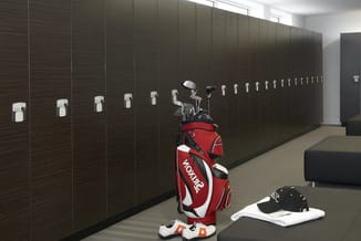 Donkerbruine garderobekastenwand met witte handgrepen in lange rij, golfbagje rood-wit en sportschoenen op betonvloer.