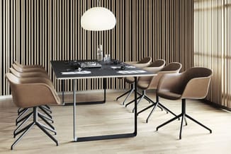 Vergaderruimte met zwarte rechthoekige tafel, beige stoelen met zwart metalen onderstel, verticale zwart-witte lamellen op ac