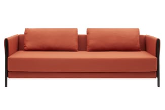 Moderne bank met terracottarood stofbekleding, twee kussens, zwart houten frame en minimalistisch design.