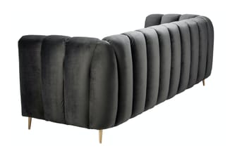 Grijze fluwelen sofa met geribbelde rugkussens en gouden poten, zijaanzicht.