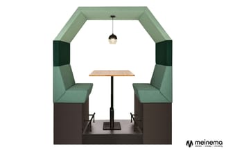 Vergaderingspod met groen gestoffeerde zijwanden, zwarte hoekpanelen, twee groene stoelen, houten tafel en hangende lamp.