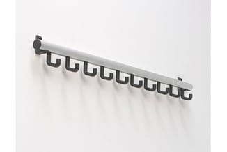 Garderoberek met witte staaf en zwarte kunststof haken aan witte wand gemonteerd.