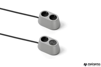 Twee grijze stopcontactblokken met zwarte kabel. Bovenste met twee stopcontacten, onderste met één stopcontact en twee USB-C