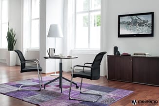 Modern kantoorinterieur met zwarte stoelen rond zwarte tafel, paarse vloerkleed, witte lamp, donkerbruine kast en wandmonteer