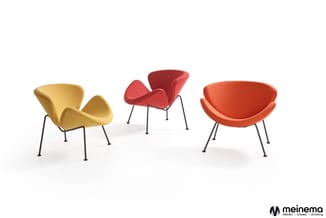 Drie moderne loungefauteuils in geel, rood en oranje met zwarte metalen poten op witte achtergrond. Meinema-logo rechtsonder.