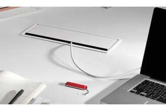Minimalistische werkplek met wit bureau, zwart-wit linearlight bovenblad, rode pen, notitieboek en laptop rechts.
