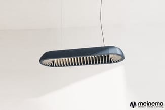 Zwarte hangende akoestische lamp met geribbelde structuur en natuurlijke binnenafwerking, verlicht tegen witte wand.