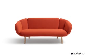 Rode sofa met afgeronde armsteunen en houten poten, tegen witte achtergrond.