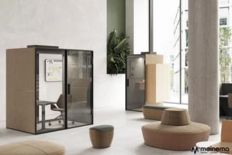 Moderne kantoorruimte met twee akoestische belcellen in natuurtinten, ronde loungebanken en poefs rond betonnen zuil, groene